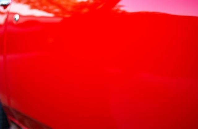Vibrantly glossy red car exterior after professional detailing service